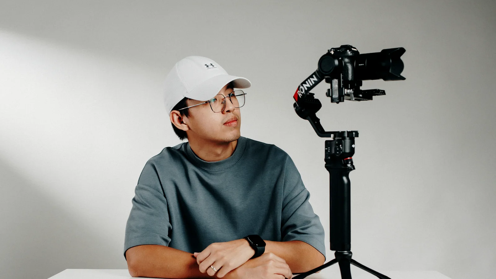 Ace beside a camera gimbal in a studio portrait